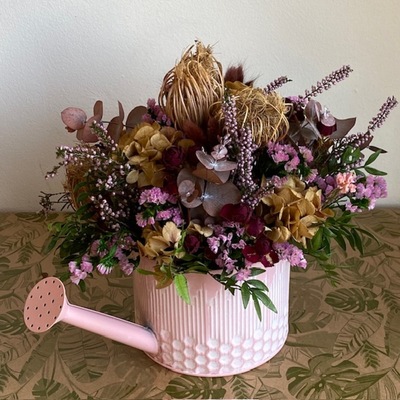 regadera rosa con flores secas y preservadas