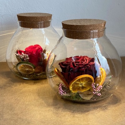 Botella iluminada con rosa preservada